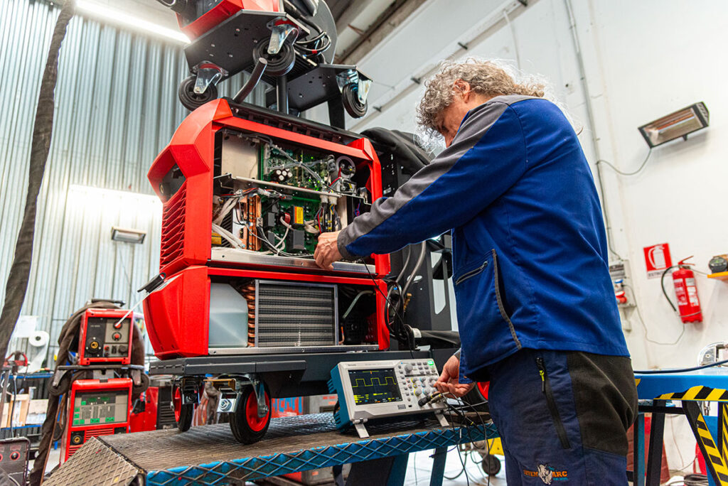 Tecnico Seven Arc Building utilizza laptop per configurare apparecchiature industriali.